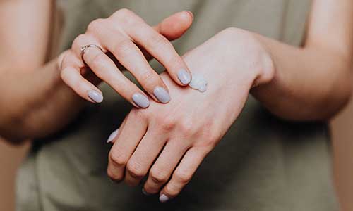 Woman applying wart removal cream